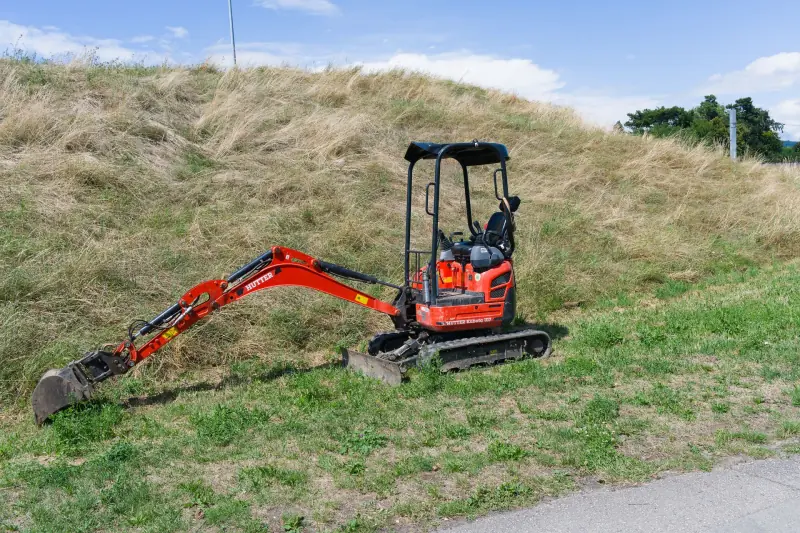 Pelleteuse en travaux de terrassement dans un jardin
